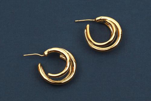 modern-gold-women-s-earrings-dark-blue-textured-background